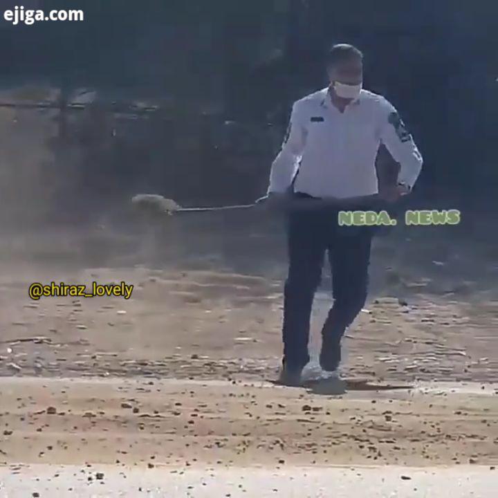 .عضو پلیس راه هرمزگان در جاده میناب در حال پاشیدن خاک بر روی گازوییل نشتی از یک کامیون برای جلوگیری